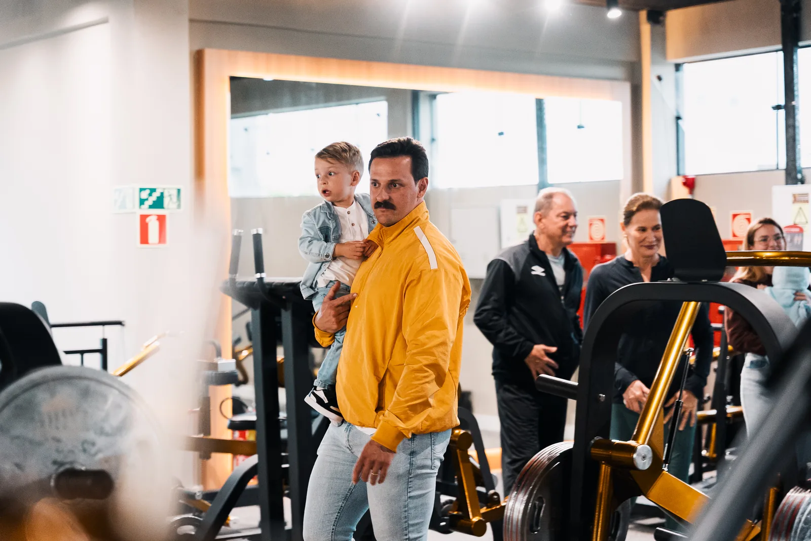 Adulto com criança no colo no ambiente da Templo Fitness